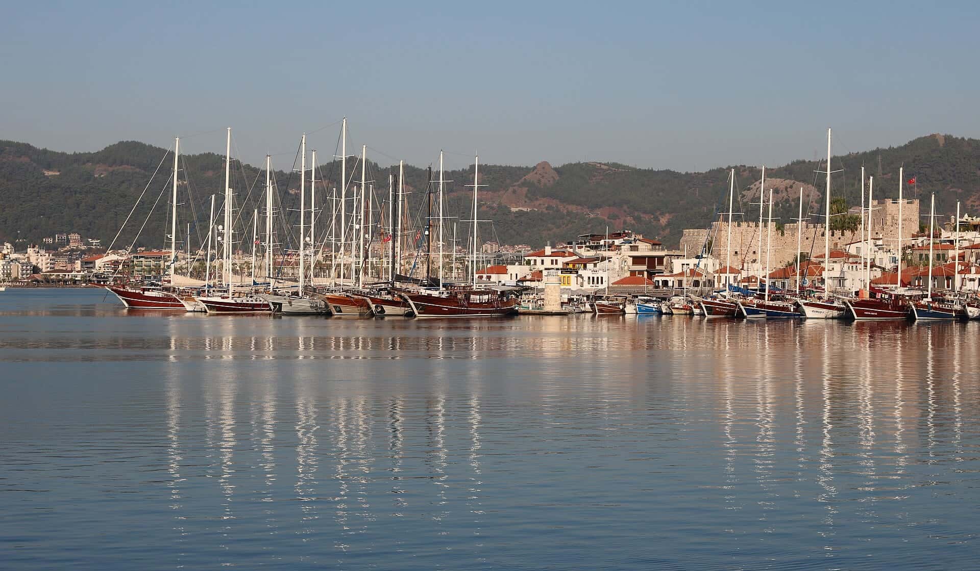 Marmaris limanında demirli guletler ve yatlar, arkada kale ve eski şehir